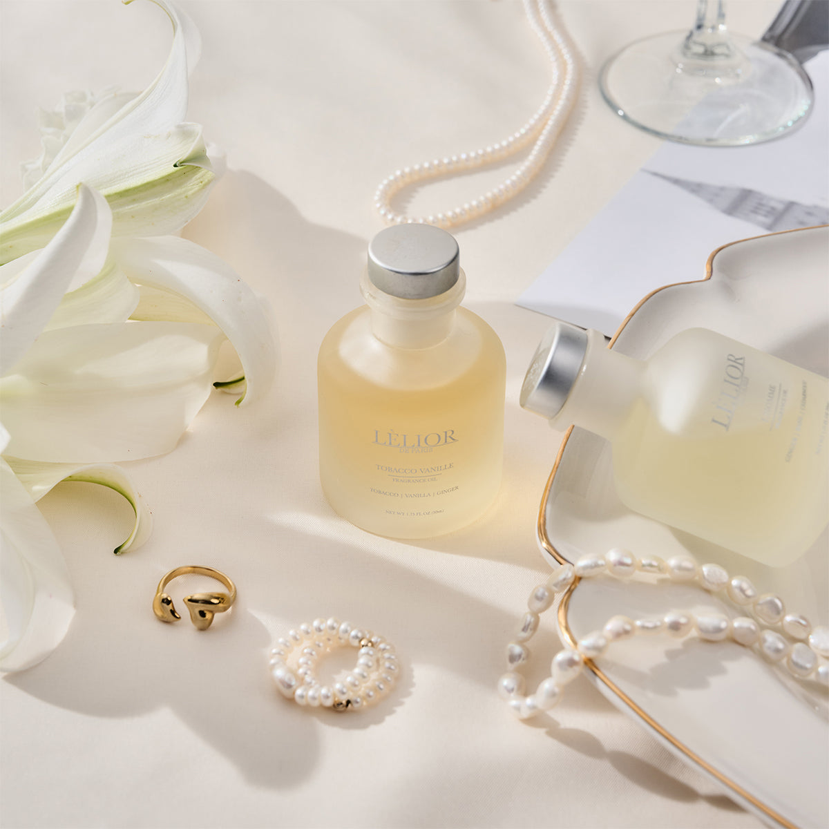 Designer Capsule Collection featuring two elegant fragrance bottles surrounded by luxurious designer jewelry, highlighting the sophisticated aesthetic of the collection.