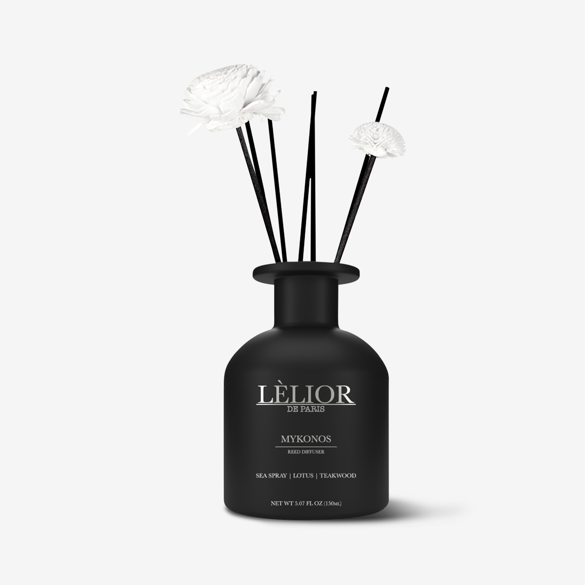 Luxury 150ml black glass reed diffuser with silver lettering, two reed flower sticks, and extra reed sticks. Mykonos scent with notes of sea spray, lotus, and teakwood described on the bottle. White background. 