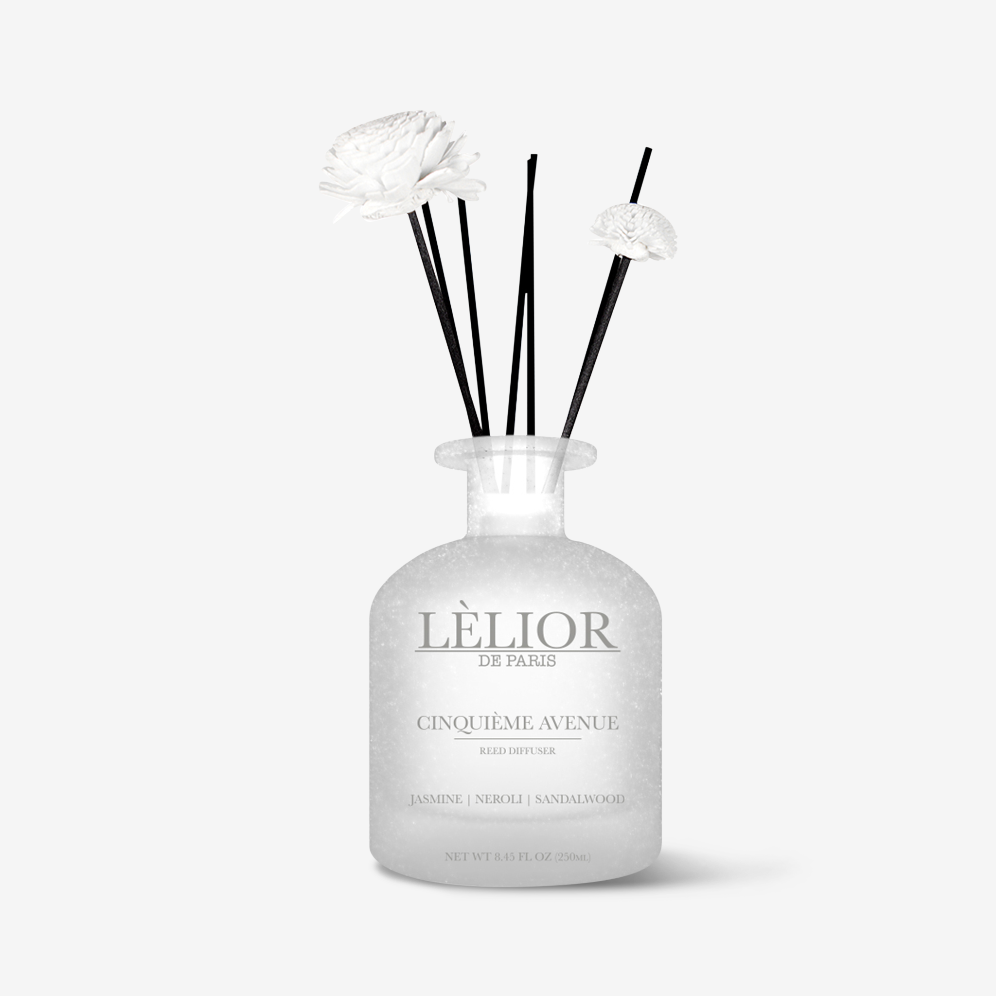 250ml frosted glass bottle with 2 flower reed sticks and extra reeds. Cinquième Avenue scent with notes of jasmine, neroli, and sandalwood described on the bottle. Silver lettering on bottle. White background.